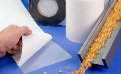 Wear-surface tape application with a lined material-handling chute